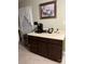 Functional kitchenette with dark wooden cabinetry, white countertops, and a coffee station at 9808 Arbor Dale Ave, Charlotte, NC 28215