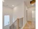 Hallway with light wood floors, white walls, and wood railing staircase at 0004 Mission Church Rd, Locust, NC 28097