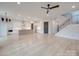 Open concept living room featuring a kitchen island, staircase, and modern light fixtures at 0004 Mission Church Rd, Locust, NC 28097