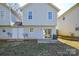 Exterior view of the home's backyard with sliding glass doors and a small patio at 1008 Beaugard Dr, Charlotte, NC 28208