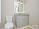 Bathroom featuring a toilet, vanity with granite countertop, and a framed mirror at 1008 Beaugard Dr, Charlotte, NC 28208