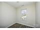 A bright bedroom offers a window, wood-look flooring, and neutral paint at 1008 Beaugard Dr, Charlotte, NC 28208