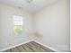 Modest bedroom features wood floors and a window to let in natural light at 1008 Beaugard Dr, Charlotte, NC 28208