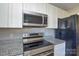 Modern stainless steel oven and stovetop in an updated kitchen with granite counter tops at 1008 Beaugard Dr, Charlotte, NC 28208