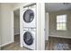 Laundry area featuring stacked washer and dryer, conveniently located near a bedroom with a window at 1008 Beaugard Dr, Charlotte, NC 28208