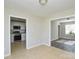 Open living space with tile flooring connecting to the kitchen and a separate room with newer dark flooring at 1008 Beaugard Dr, Charlotte, NC 28208