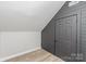 Finished attic featuring gray wood paneling and sleek flooring, ideal for versatile use and storage at 102 S Liberty St, Gastonia, NC 28052