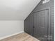 Attic featuring gray walls, wood-look floors, and a small storage room at 102 S Liberty St, Gastonia, NC 28052