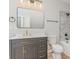 Bathroom featuring a gray vanity with gold accents, a toilet, and a tiled shower at 102 S Liberty St, Gastonia, NC 28052