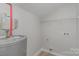 Utility room with a water tank, storage shelving, and sleek flooring, blending practicality and functionality at 102 S Liberty St, Gastonia, NC 28052