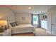 Bright bedroom featuring carpet flooring, a large window with blue patterned curtains, a full bed and a white dresser at 107 Windstone Common Ln, Mooresville, NC 28117