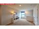 Bright living room featuring neutral walls, carpet flooring, a storage unit and a window with blue patterned valance at 107 Windstone Common Ln, Mooresville, NC 28117