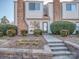 Inviting townhome entrance with brick accents, steps, and manicured bushes at 10901 Carmel Crossing Rd, Charlotte, NC 28226