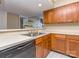 Functional kitchen featuring wood cabinets, stainless steel sink, and dishwasher at 10901 Carmel Crossing Rd, Charlotte, NC 28226