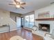 Comfortable living room features a white brick fireplace, large window and hardwood floors at 10901 Carmel Crossing Rd, Charlotte, NC 28226