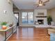 Bright living room showcasing a white brick fireplace, large window, and hardwood floors at 10901 Carmel Crossing Rd, Charlotte, NC 28226