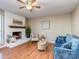 Inviting living room featuring a brick fireplace, seating, and hardwood floors at 10901 Carmel Crossing Rd, Charlotte, NC 28226