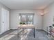 Bright home office featuring a modern desk, neutral walls, and a large window for natural light at 10901 Carmel Crossing Rd, Charlotte, NC 28226