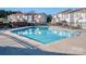 Community pool with chaise lounges and nearby condominium buildings on a clear, sunny day at 10901 Carmel Crossing Rd, Charlotte, NC 28226