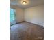 A bright and airy bedroom with neutral walls and carpet, featuring a window with blue curtains at 1301 Waylon Ave, Gastonia, NC 28054