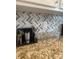 Close-up of a granite countertop and gray-and-white backsplash in the kitchen at 1301 Waylon Ave, Gastonia, NC 28054