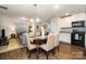 This bright dining area features hardwood floors, a chandelier, and connects seamlessly to the kitchen and living room at 1301 Waylon Ave, Gastonia, NC 28054