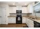 Modern kitchen features white cabinets, black appliances, granite countertops, and stylish backsplash at 1301 Waylon Ave, Gastonia, NC 28054