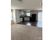 Open concept living room and kitchen featuring modern appliances and neutral carpeting at 1301 Waylon Ave, Gastonia, NC 28054