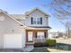 Inviting two-story home featuring a brick facade, front porch, attached garage, trimmed yard and well-manicured landscape at 136 Ridge Bluff Rd, Mooresville, NC 28115