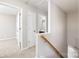 Upstairs hallway features carpet flooring, wood railing, and a view to a bathroom at 136 Ridge Bluff Rd, Mooresville, NC 28115