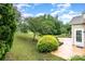 Well-maintained backyard featuring lush greenery, mature trees, and a patio area at 14309 Stonewater Ct, Fort Mill, SC 29707