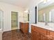 Bathroom with double vanity sinks, framed mirrors, walk-in closet with wire shelving, and tile flooring at 14309 Stonewater Ct, Fort Mill, SC 29707