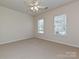 Neutral bedroom with carpet, ceiling fan, and natural light from two windows at 14309 Stonewater Ct, Fort Mill, SC 29707