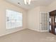 Comfortable carpeted bedroom with a large window, neutral walls, and a glimpse of an adjacent living space at 14309 Stonewater Ct, Fort Mill, SC 29707