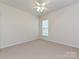 A carpeted room featuring a ceiling fan and a window allowing for natural light at 14309 Stonewater Ct, Fort Mill, SC 29707