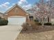 Charming brick home with a well-manicured front yard and blossoming tree in a suburban setting at 14309 Stonewater Ct, Fort Mill, SC 29707