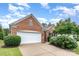 Garage exterior featuring a brick facade, white garage door and trim, and mature landscaping at 14309 Stonewater Ct, Fort Mill, SC 29707