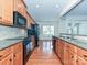 Galley kitchen featuring granite countertops, modern appliances, and a seamless flow to the living spaces at 14309 Stonewater Ct, Fort Mill, SC 29707