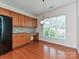 Bright kitchen features wood cabinets, granite counters, tiled backsplash, stainless refrigerator, and hardwood floors at 14309 Stonewater Ct, Fort Mill, SC 29707