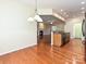 Open kitchen view showcases hardwood floors and stylish lighting, flowing seamlessly to a cozy fireplace at 14309 Stonewater Ct, Fort Mill, SC 29707