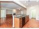 Modern kitchen island with granite counters, wood cabinets, and stainless dishwasher overlooks a bright living area at 14309 Stonewater Ct, Fort Mill, SC 29707