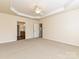 Spacious main bedroom with carpeted floors, ceiling fan, tray ceiling, and access to the ensuite bathroom at 14309 Stonewater Ct, Fort Mill, SC 29707