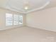 Spacious main bedroom with carpeted floors, ceiling fan, tray ceiling, and plenty of natural light at 14309 Stonewater Ct, Fort Mill, SC 29707