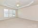 Spacious main bedroom with a tray ceiling, ceiling fan, and three large windows at 14309 Stonewater Ct, Fort Mill, SC 29707