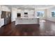 Open kitchen with white cabinets, stainless steel appliances, an island with seating, and hardwood floors at 15633 Aviary Orchard Way, Charlotte, NC 28278