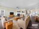 Bright living room featuring a fireplace, comfortable seating, and hardwood floors with views into the kitchen at 15633 Aviary Orchard Way, Charlotte, NC 28278