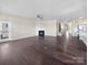 Spacious living room with hardwood floors, neutral paint, a fireplace, and abundant natural light at 15633 Aviary Orchard Way, Charlotte, NC 28278