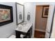 Stylish powder room with decorative mirror, dark wood vanity, and marble countertops at 16116 Lakeside Loop Ln, Cornelius, NC 28031