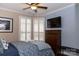 Bedroom featuring a ceiling fan, plantation shutters, and a TV at 16116 Lakeside Loop Ln, Cornelius, NC 28031