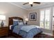 Bedroom featuring a ceiling fan, plantation shutters, and a comfortable bed at 16116 Lakeside Loop Ln, Cornelius, NC 28031